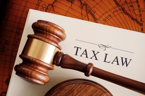 Tax Law wrriten on paper with a gavel on it.
